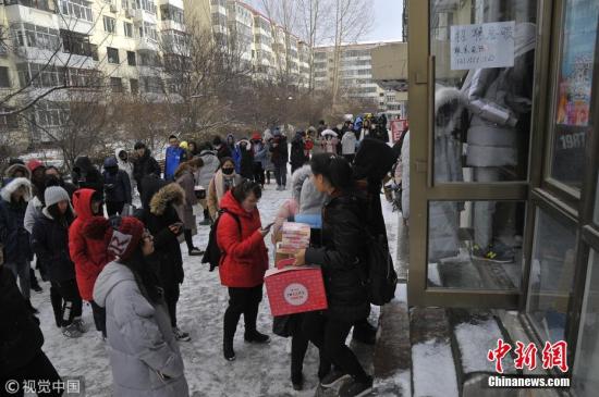资料图：哈尔滨市某高校，寒冷的冬天大学生们雪地中排队领取双十一快递。 图片来源：视觉中国