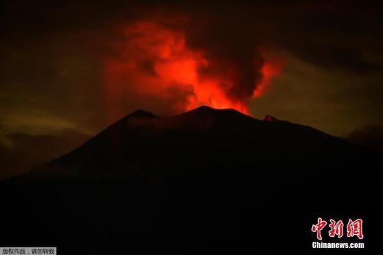 印尼巴厘岛阿贡火山自11月21日首次喷发后，活跃强度不断增强并多次喷发出大量火山灰。图为当地时间11月30日拂晓前的阿贡火山烟雾染红天际。