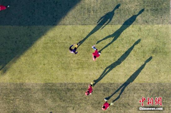 12月9日，无锡江阴老体育场，业余体育学校的孩子们踢球的动作在草坪上形成长长的影子，从空中俯瞰，别有一番趣味。 <a target='_blank' href='http://www.chinanews.com/'>中新社</a>记者 泱波 摄