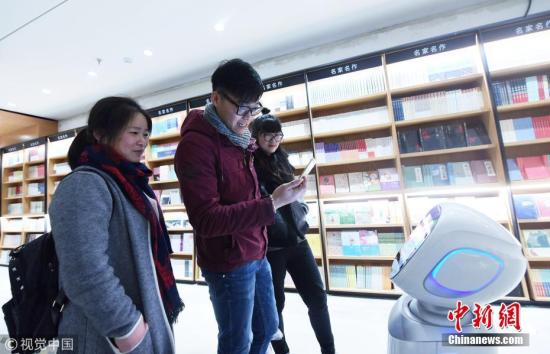 资料图：一书店内，人工智能机器人“小新”与读者互动和导购，让读者感受到新书店智能魅力。龙巍 摄 图片来源：视觉中国
