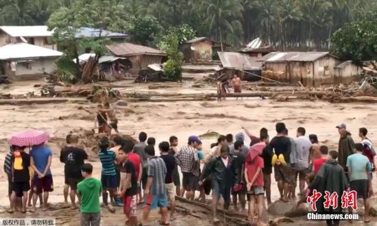 社交网络上的图片显示，在菲律宾北拉瑙省，洪水滚滚而过，人们用绳索解救被困住的居民。