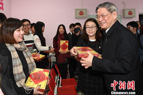 1月20日，国台办主任张志军来到北京中国人民大学，走访该校台湾学生宿舍，并与在校台生开展座谈等互动活动。图为张志军向参与座谈会的台湾师生代表赠送节日礼物。 中新社记者 崔楠 摄