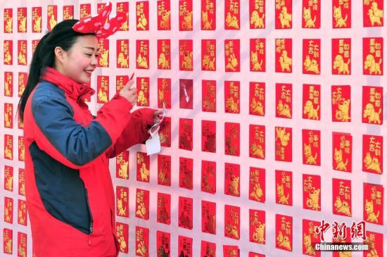 2月16日，大年初一，游客来到天津方特欢乐世界红包墙前抢包红。<a target='_blank' href='http://www.chinanews.com/'>中新社</a>记者 佟郁 摄