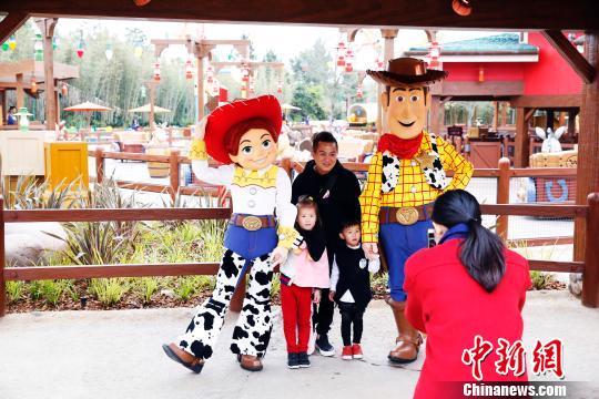 资料图：上海迪士尼胡迪、翠丝与游客合影。　汤彦俊 摄