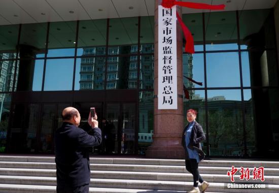 4月10日，新组建的国家市场监督管理总局在北京正式挂牌。图为民众与新牌合影。<a target='_blank' href='http://www.chinanews.com/'>中新社</a>记者贾天勇摄