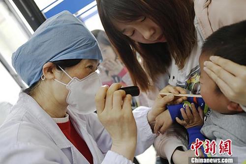4月12日，在上海复旦大学附属儿科医院的手足口病诊室，医生正在为孩子诊断。日前，国家卫生健康委员会例行发布会上透露，中国已进入手足口病流行期，3月份中国手足口病报告病例已达2.8万例。预计今年手足口病整体流行强度将高于去年。 中新社记者 殷立勤 摄