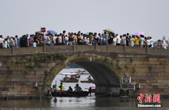 资料图：西湖断桥挤满了游客。 /p中新社记者 王刚 摄