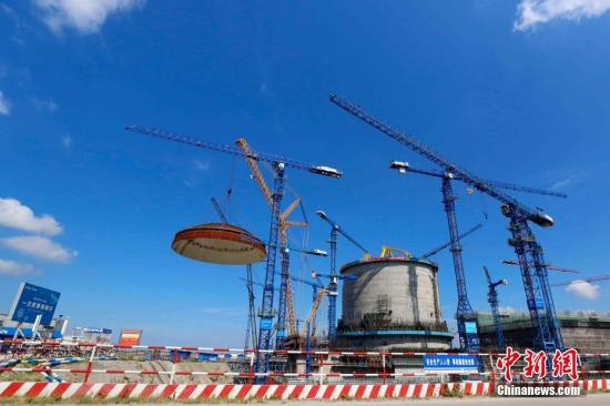 5月23日，中国广核集团防城港核电二期工程3号机组穹顶吊装顺利完成，这标志着作为英国“华龙一号”核电项目参考电站的防城港3号机组从土建施工阶段全面转入设备安装阶段。华龙一号核电技术是由中国自主研发，具有完全自主知识产权的第三代核电技术，也是当今世界核电领域在建设中的最为先进的核电技术之一。图为防城港核电二期工程3号机组穹顶吊装现场。 中新社发 黄穗芳 摄