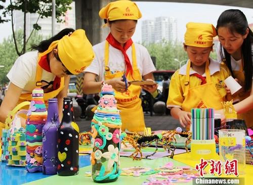 资料图：2018年6月5日世界环境日，小朋友们在志愿者的指导下利用各种废弃物制作各种工艺品。/p中新社记者 张娅子 摄