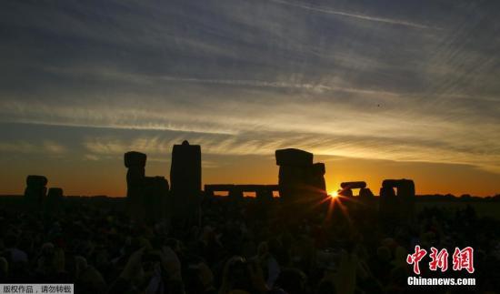 当地时间6月21日，英国英格兰威尔特郡，人们聚集在巨石阵附近观看日出，迎接夏至日到来。