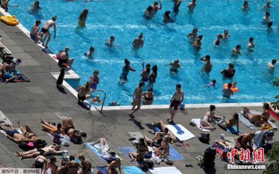 资料图：高温天气，泳池岸上水里都挤满来消暑的人。