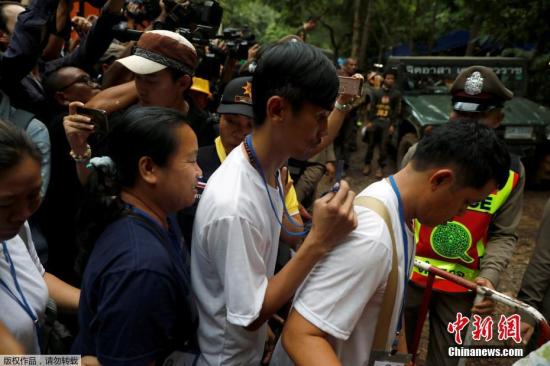当地时间2018年7月4日，泰国警察护送被困足球队成员家属前往溶洞。