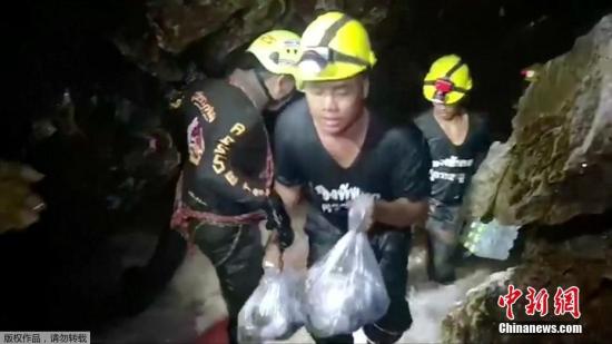 图为营救人员在往溶洞内运送救援所需的物资。泰国当局表示，这名救援人员的遇难是缺氧所致。目前洞穴内的氧气正在不断失去，这名救援人员是任务是为被困的小球员们输送氧气，但在洞穴内放至氧气罐后，这名救援人员便失去了知觉。