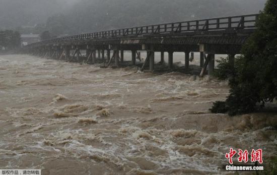 资料图：当地时间2018年7月6日，日本京都，由于梅雨前锋的影响，近日从东日本到西日本广大地区普降大雨，多地降雨量刷新历史纪录。这种罕见的暴雨天气已严重影响到日本民众的正常生活，其中京都、高知两地河流水位暴涨，决堤的可能性很高。现已发生数起人被冲走后下落不明的事故。