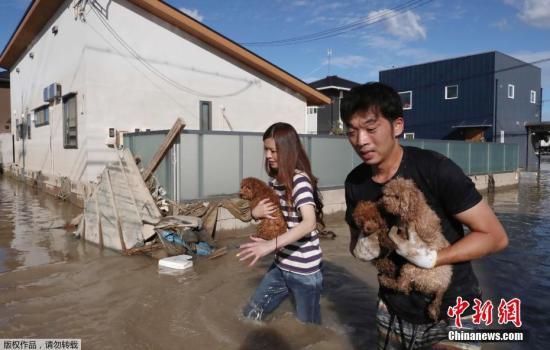 当地时间7月8日，日本仓敷，当地民众将宠物带离被洪水围困区域。