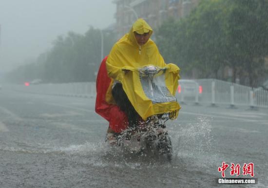 资料图：北京民众在雨中出行。中新社记者 杨可佳 摄