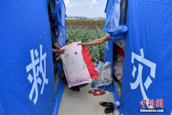 8月14日，当地民众在救灾帐篷内搭建临时床铺。 中新社记者 任东 摄