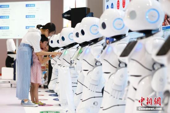 资料图：2018世界机器人大会上，小朋友与机器人互动。 中新社记者 富田 摄
