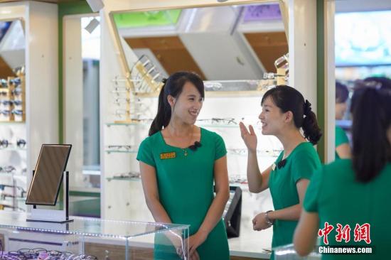 朝鲜柳京眼科综合医院的眼镜店里，两名朝鲜姑娘正在谈笑。《中国新闻周刊》记者 甄宏戈 摄
