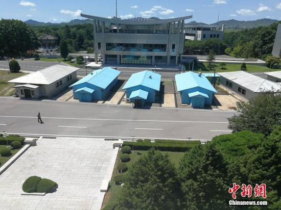 三个蓝色建筑是军事分界线上的会议室，外面过道上横卧着一条低窄的水泥墩，这是朝韩军事分界线的标志。2018年4月27日上午，金正恩迈步跨过水泥墩，成为朝鲜战争之后第一位踏上韩国土地的朝鲜最高领导人。/p中新网记者 邱宇 摄