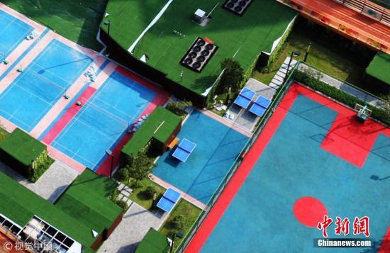 资料图：2018年8月26日，重庆一商场的5楼楼顶建“空中运动场”免费对市民开放。据了解，该运动场投资1000万元人民币，共1.7万平方米，环形天空跑道包围楼顶，中间设有4个乒乓球场、3个羽毛球场、1个标准篮球场和游戏区。谢谢 摄 图片来源：视觉中国