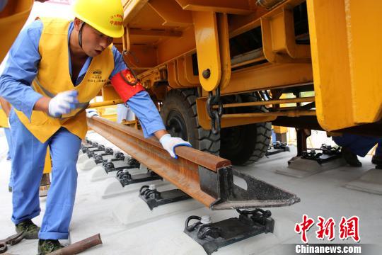 在中铁十一局一公司施工管段内，中铁十一局建设者进行铺轨作业 杨东 摄