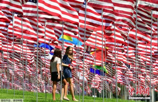 当地时间2018年9月10日，游客在美国加利福尼亚马里布佩珀丁大学参观“国旗飘扬”展览。该展览每年举行，其展出的2997面国旗是为了纪念2001年9月11日“911”恐怖袭击的受害者.