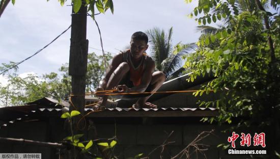 当地时间9月13日，菲律宾伊洛科斯省居民加固房屋，为抵御超强台风“山竹”做准备。