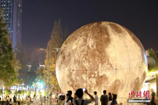 资料图：随着中秋佳节的临近，一轮“大月亮”亮相南京街头，吸引了大批市民前来驻足留影。中新社记者 泱波 摄