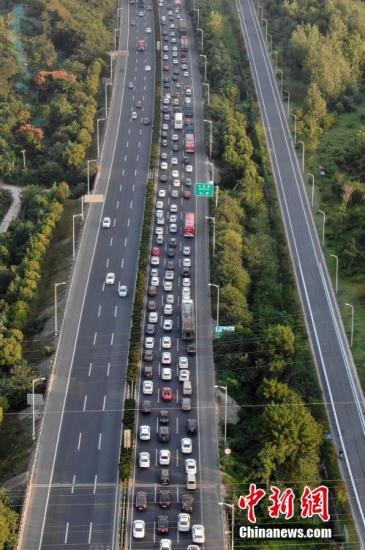 10月1日，大批车辆缓慢行驶在南京绕城高速公路上。当日是中国国庆长假首日，大批民众或探亲访友或出游，多地出现出行高峰，高速开启拥堵模式。中新社记者 泱波 摄