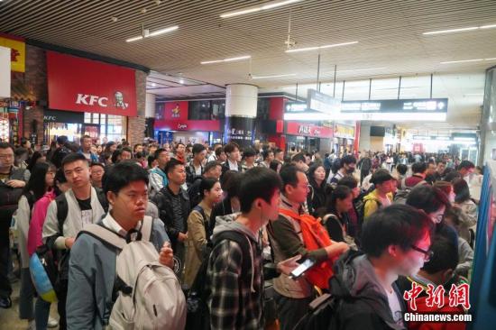 10月1日，旅客在北京南站内自动取票机前排队取票。当天是国庆假期首日，北京南站迎来客流高峰。此前，据北京铁路局预计，国庆黄金周将发送旅客1168万人，同比增加19.9万人。其中10月1日为出行高峰日，预计当天发送旅客143万人，同比增加4.7万人。<a target='_blank' href='http://www.chinanews.com/'>中新社</a>记者 张兴龙 摄
