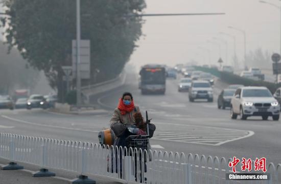 11月3日，北京市民在雾霾中出行。当日10时，北京空气质量指数为215，全市陷五级重度污染。中新社记者 刘关关 摄