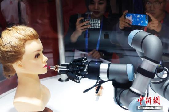 在首屆進博會的歐萊雅展臺上，一款美妝機器人吸引瞭許多女性參觀者的目光。該機器人會畫眉毛刷腮紅，5分鐘能完成一個妝容。湯彥俊 攝