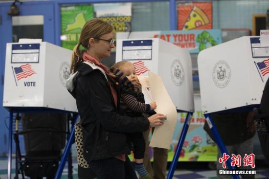 当地时间11月6日，美国2018年中期选举投票日，纽约一位母亲带着幼子在位于布朗克斯区的一处投票站投票。<a target='_blank' href='http://www.chinanews.com/'>中新社</a>记者 廖攀 摄