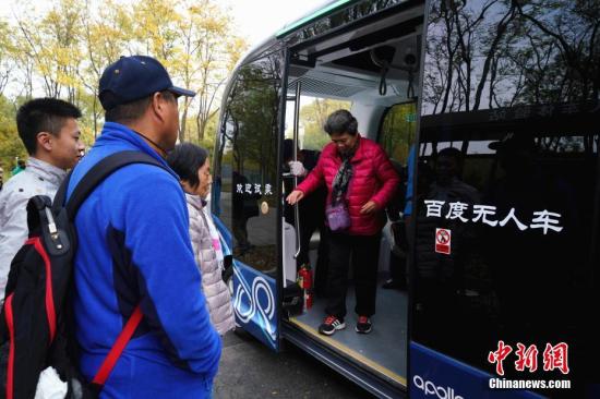 11月7日，在北京海淀公園，市民體驗無人駕駛的阿波龍小巴車。該無人車內沒有方向盤，沒有雨刷器，也沒有司機駕駛座，在行駛過程中可通過車身四周的雷達等傳感器，實時避障、自助規劃行駛路線。近日，經過改造，海淀公園變身全球首個AI科技主題公園，前來游玩的市民可以免費體驗包括無人小巴、智能跑道、智能鋼琴步道、AR太極教練等在內的多種人工智能設備。<a target='_blank' >中新社</a>記者 張興龍 攝