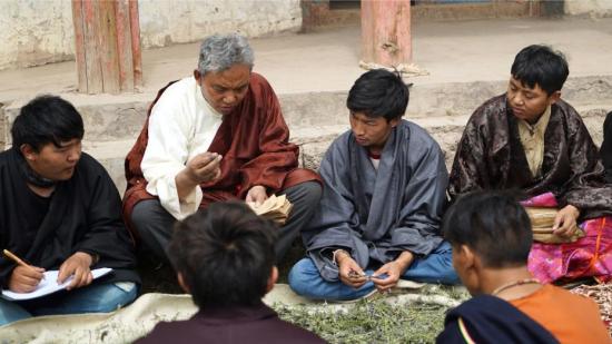 其木居曼巴（世袭家族医生）丹松扎巴(左二)为学生讲授辨认药浴药材的方法。刘罡 摄 中国非物质文化遗产保护中心供图