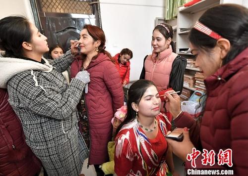 12月6日，新疆英吉沙县萨罕乡阔坦村活动室内，由村里妇女组成的模特队在准备走秀前的妆容。<a target='_blank' href='http://www.chinanews.com/'>中新社</a>记者 刘新 摄