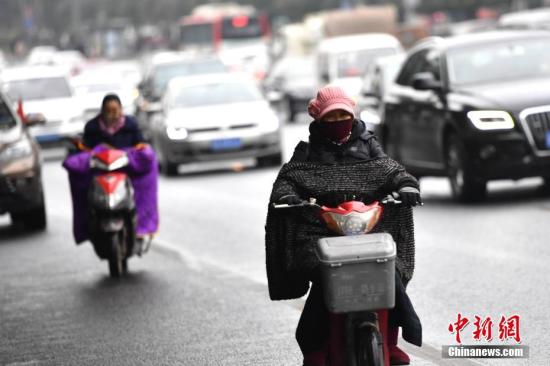 12月25日，受冷空气影响，中国多地出现降温天气，局部地区还发布了寒潮蓝色预警。图为“全副捂装”出行的成都市民。 张浪 摄