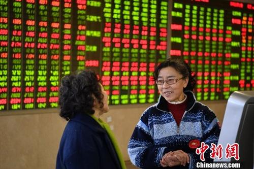 1月11日，股民在四川成都某证券交易大厅内讨论交流。(资料图)/p中新社记者 刘忠俊 摄