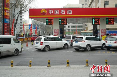 资料图为1月14日，青海西宁的车辆排队加油。/p中新社记者 李培源 摄