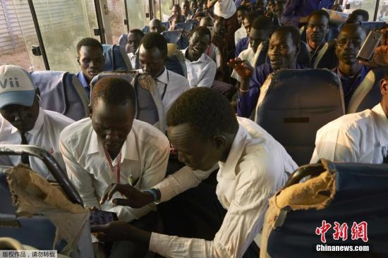 资料图：当地时间2019年1月24日，南苏丹全国期末考试举行，来自卢旺达的维和部队护送平民保护区(PoC)的高中生前往首都朱巴进行考试。由于平民保护区(PoC)缺乏足够的考试设施和空间，该区域的319名男生和57名女生须乘坐公共汽车前往首都朱巴的一所学校参加考试。目前，来自南苏丹各地的大约35000名流离失所者仍居住在该国首都郊区的两个难民营。图为考生前往南苏丹朱巴进行期末考试。