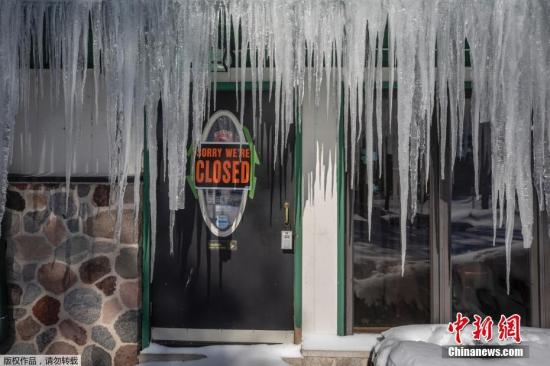 近日，一股强劲的北极寒流将袭击美国，数以百万计居民面临可能破纪录的危险低温。报道称，30日美国中西部将达到自上世纪九十年代中期以来的最低温。图为威斯康星州一家酒吧门前悬挂的冰柱。