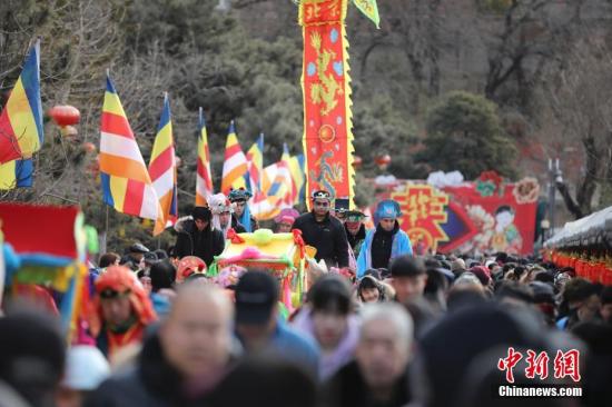 2月9日，游客在北京八大处公园庙会上游玩，观看传统民间花会表演。 /p中新社记者 盛佳鹏 摄