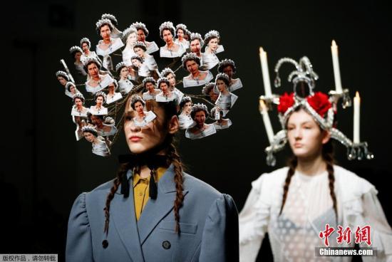 当地时间2月19日，伦敦时装周上的一场秀，服装似乎成了配角，而模特的发式造型抢了不少风头，一名模特头上插满英国女王的头像。