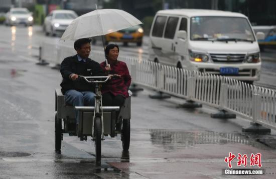 资料图：民众在雨中出行。<a target='_blank' href='http://www.chinanews.com/'>中新社</a>记者 贾天勇 摄