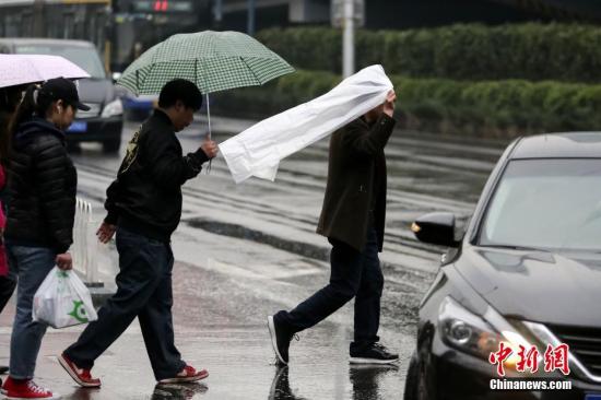 3月20日下午，北京迎来降雨，气温下降。北京市气象台19日发布了今年来首个寒潮预警，预计3月20至21日北京地区将出现寒潮天气，最低气温将下降8至10℃。图为民众在雨中出行。<a target='_blank' href='http://www.chinanews.com/'>中新社</a>记者 贾天勇 摄