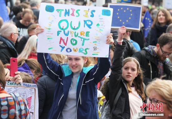 3月23日，在欧盟同意英国延迟脱欧、英国脱欧前景仍面临“灾难的不确定性”困境之际，伦敦市中心举行了大规模呼吁举行“第二次脱欧公投”的示威游行。名为“交给人民”的组织者声称，参加示威游行的英国民众来自全国各地，超过一百万人。图为高举标语的少女。/p中新社记者 张平 摄