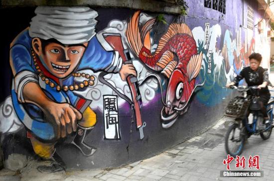 资料图：在福州市朱紫坊历史文化街区，行人从时尚的涂鸦壁画前走过。<a target='_blank' href='http://www.chinanews.com/'>中新社</a>记者 吕明 摄