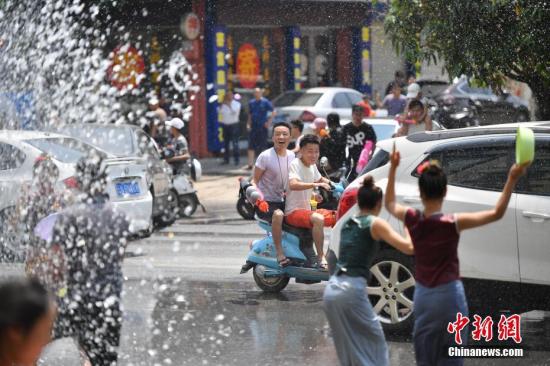 资料图：在云南省德宏傣族景颇族自治州瑞丽市，泼水节期间，民众相约走上街头泼水狂欢。<a target=