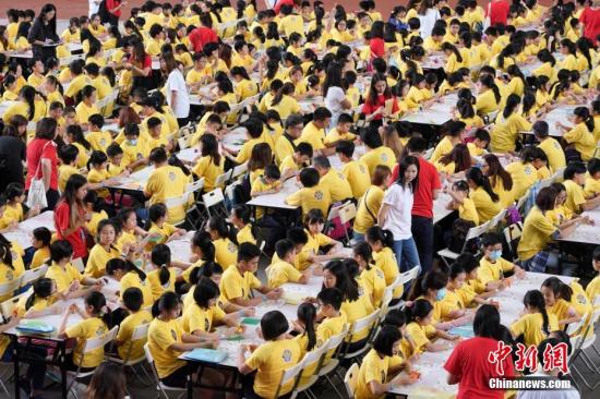4月19日，香港赛马会在沙田马场举行“同心创世界纪录·最大规模的折纸课”活动，最终在1073名中小学生和市民的共同努力下，创造了“世界上最大规模的折纸课”这一新的健力士（吉尼斯）世界纪录。图为1073人同时折纸。<a target='_blank' href='http://www.chinanews.com/'>中新社</a>记者 张炜 摄